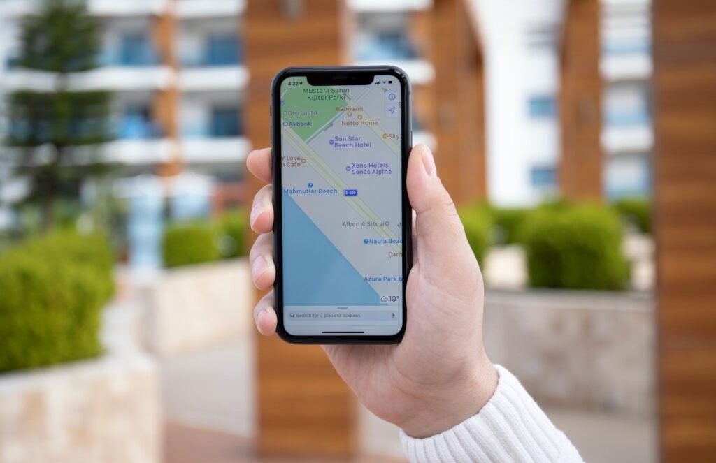 Ads might be coming to Apple Maps next year Man hand holding iPhone 11 with Apple map on screen