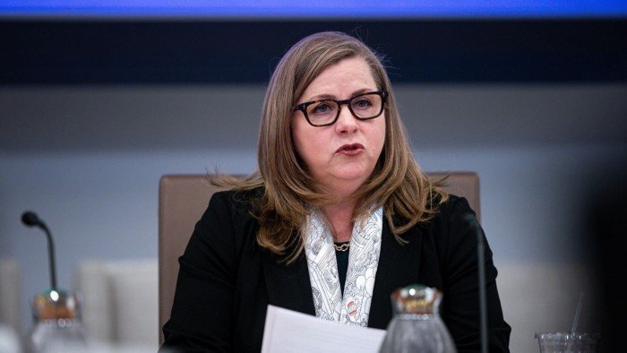Federal Reserve plans to shrink board of top banking supervisor Michelle Bowman speaks at a meeting, holding papers and seated at a table with microphones and water pitchers.