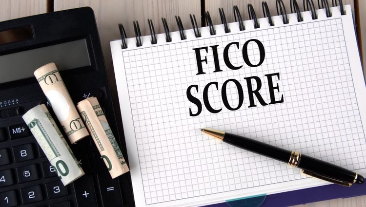 Gen Z faces steepest drop in credit scores as economic pressures mount FICO SCORE - words in a notebook on the background of a calculator and banknotes
