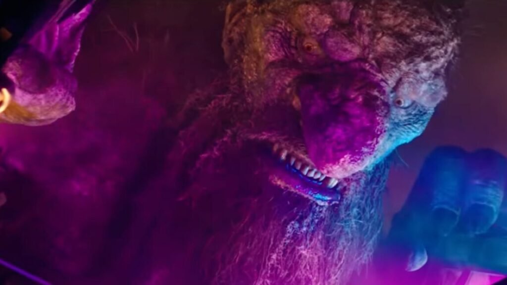 closeup of a giant troll with purple and pink nightclub lights playing off his boulder-like face.